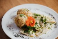 um prato de comida com almôndegas e uma flor em cima. em Plattnerhof Viums em Naz-Sciaves