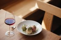 uma tigela de almôndegas ao lado de uma taça de vinho em Plattnerhof Viums em Naz-Sciaves