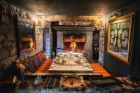 uma sala de jantar com uma mesa e uma lareira em Country House La Bursch em Campiglia Cervo