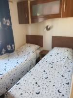 two twin beds in a small room with at La Chanterie Agréable Mobil-Home Résidentiel Normand in Saint-Pair-sur-Mer