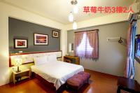 a bedroom with a white bed and a window at 草莓牛奶台東民宿可洽包棟 in Taitung City