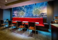 ein Esszimmer mit einer roten Bank und Stühlen in der Unterkunft La Quinta by Wyndham Time Square South in New York