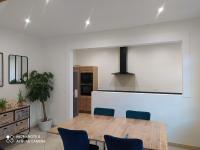 a kitchen with a wooden table and blue chairs at Maison de maître, un coin de verdure en hyper centre in Lisieux