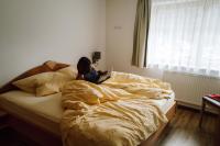 a woman sitting on a bed with a laptop at Spatla Appartements in Gaschurn