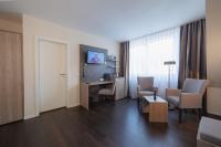 a hotel room with a desk and a table and chairs at Hotel Jellentrup in Münster