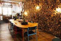 a wooden table and chairs in a room with a stone wall at Eau Berges in Vicdessos
