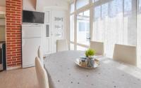 a kitchen with a table and chairs and a white refrigerator at Apartments Ante in Pakoštane