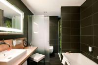 a bathroom with a sink and a tub and a toilet at NH Frankfurt Messe in Frankfurt
