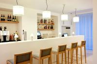 a bar with chairs and a counter with wine bottles at NH Frankfurt Messe in Frankfurt