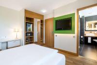 a bedroom with a bed and a bathroom with a sink at NH Frankfurt Messe in Frankfurt