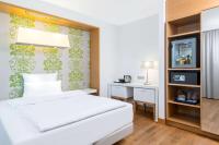 a hotel room with a bed and a desk at NH Frankfurt Messe in Frankfurt