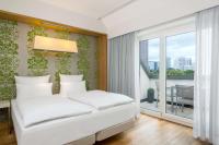 a bedroom with a white bed and a balcony at NH Frankfurt Messe in Frankfurt