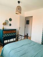 a bedroom with a blue bed and a dresser at Entre mer et falaises in Équihen-Plage