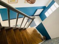 a staircase in a house with blue walls and wooden floors at Entre mer et falaises in Équihen-Plage