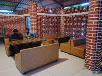 Dos personas sentadas en mesas en una habitación de ladrillo. en RAJ RESORT & BANQUETS, en Vapi