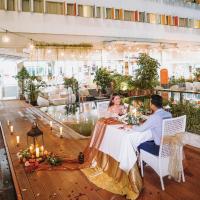 a bride and groom sitting at a table in a restaurant at HARRIS Hotel Batam Center in Batam Center