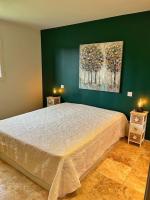a bedroom with a large bed and a green wall at Villa avec piscine privée à Sainte Lucie in Sainte-Lucie de Porto-Vecchio