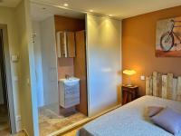 a bedroom with a bed and a bathroom with a sink at Villa avec piscine privée à Sainte Lucie in Sainte-Lucie de Porto-Vecchio