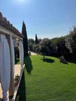 a garden with two white umbrellas and a lawn at Villa avec piscine privée à Sainte Lucie in Sainte-Lucie de Porto-Vecchio