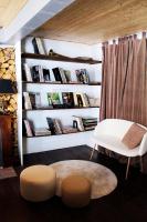 a living room with a bench and a shelf of books at Eau Berges in Vicdessos