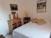 a bedroom with a white bed and a wooden dresser at 4SAP22 Appartement climatisé avec double terrasses in Collioure