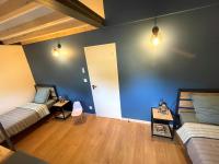 a room with two beds and a blue wall at Meublé de tourisme 4 étoiles Logis Riquet proche de Carcassonne in Caux-et-Sauzens