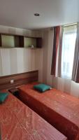 two beds in a small room with a window at Camping Oasis Village in Puget-sur-Argens