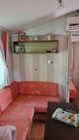 a living room with a red couch and a table at Camping Oasis Village in Puget-sur-Argens