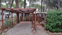 a wooden pergola in front of a house at Camping Oasis Village in Puget-sur-Argens