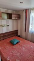 a bedroom with a red bed with a green pillow on it at Camping Oasis Village in Puget-sur-Argens