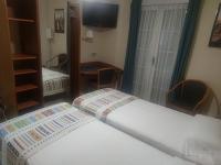 A bed or beds in a room at Hostal Burbia
