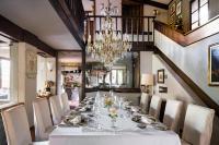 uma sala de jantar com uma mesa longa e um lustre em Country House La Bursch em Campiglia Cervo