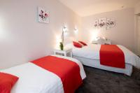 two beds in a room with red and white at Hotel Biney in Rodez