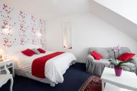 a white bedroom with a bed and a chair at Hotel Biney in Rodez