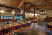 Un comedor con mesas y sillas en un edificio. en Green Mansions Jungle Resort, en Sauraha