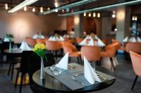 un comedor con mesas y sillas y una mesa con flores en Hunguest Bük - ex Répce és Répce Gold, en Bük