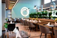 una fila de mesas y sillas en un restaurante en Hunguest Bük - ex Répce és Répce Gold, en Bük