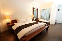 a bedroom with a large bed and a chair at Mudanwan Villa in Mudan