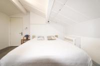 a white bedroom with a large white bed with two pillows at La Maison Joffre - Chez Marcel - Vue Fort St André - Piscine éco in Villeneuve-lès-Avignon