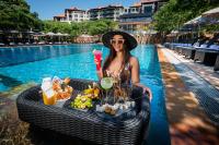 una mujer con una bandeja de comida junto a una piscina en The Capital Zimbali, en Ballito
