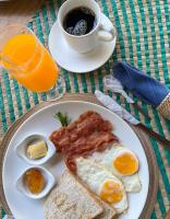 un plato con huevos tocino y tostadas y una taza de café en Vailtin Home Point, en Moalboal