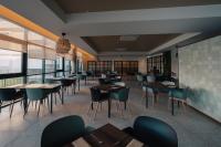 ein Restaurant mit Tischen, Stühlen und Fenstern in der Unterkunft Porto Covo Praia Hotel & SPA in Porto Covo