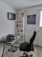 a desk with a laptop and a chair in a room at T1 meublé in Saint-Chamond