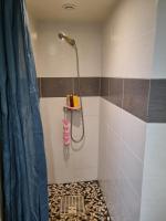 a bathroom with a shower with a tile floor at T1 meublé in Saint-Chamond