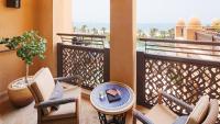 a balcony with chairs and a table with a book on it at Jumeirah Mina Al Salam Dubai in Dubai