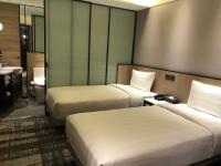 a hotel room with two beds and a bathroom at Hotel Midtown Richardson in Taipei