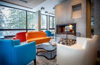 a lobby with a fireplace and colorful chairs at Hôtel Club mmv Le Flaine *** in Flaine