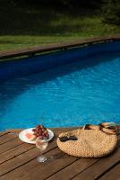 a glass of wine and a plate of fruit next to a pool at Dolyna Mykolaya in Migovo