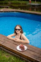 a woman sitting in a pool with a plate of fruit at Dolyna Mykolaya in Migovo