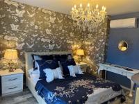 a bedroom with a bed and a chandelier at La Casa dei Sogni in Flayosc